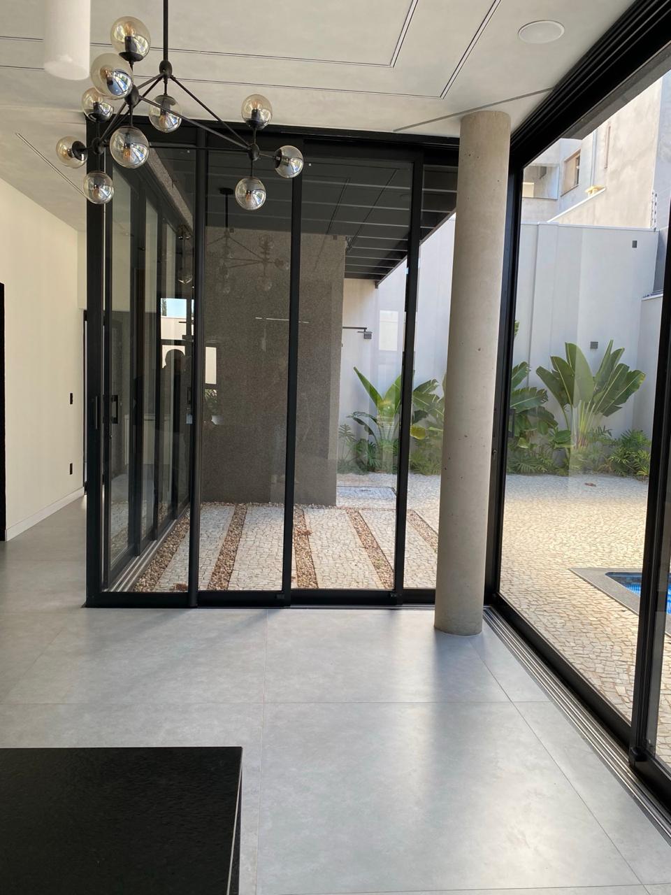 Ambiente interno com portas de vidro e vista para o pátio