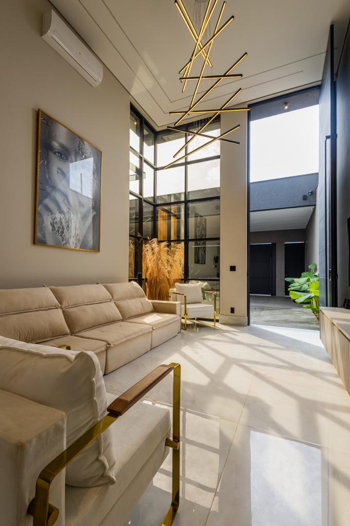 Sala de estar com pé-direito alto e esquadrias de vidro